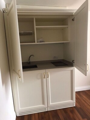 A compact kitchen with white cabinetry, a double sink, and a countertop. - Suites alla Maddalena (Venice)