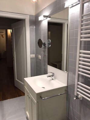 A modern bathroom with a white sink, a mirror, and a towel rack. - Suites alla Maddalena (Venice)