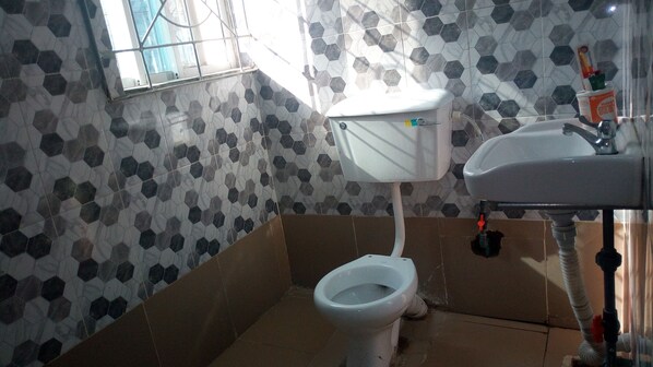A bathroom with a toilet, sink, and hexagonal patterned walls.