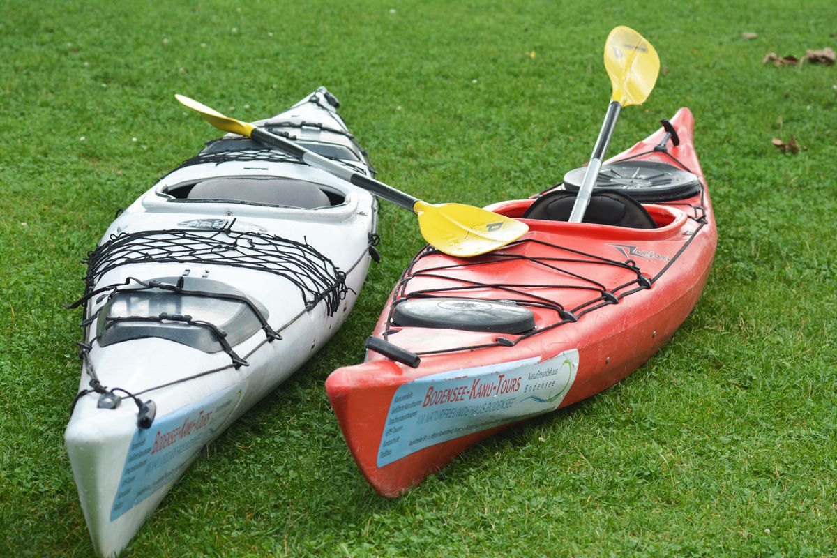 Dos kayaks sobre un campo cubierto de hierba.