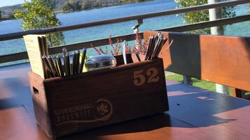 Una caja de madera con el número 52, sobre una mesa de madera con vista a un lago y árboles al fondo.