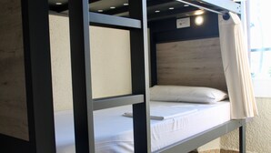 A bunk bed with a wooden headboard, a white mattress, and a white pillow. - Alberg Costa Brava - Hostel (Llanca)