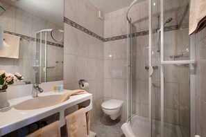 A modern bathroom with a glass-enclosed shower, a white sink, and a toilet. - Hotel Sonneneck (Bad Kissingen)