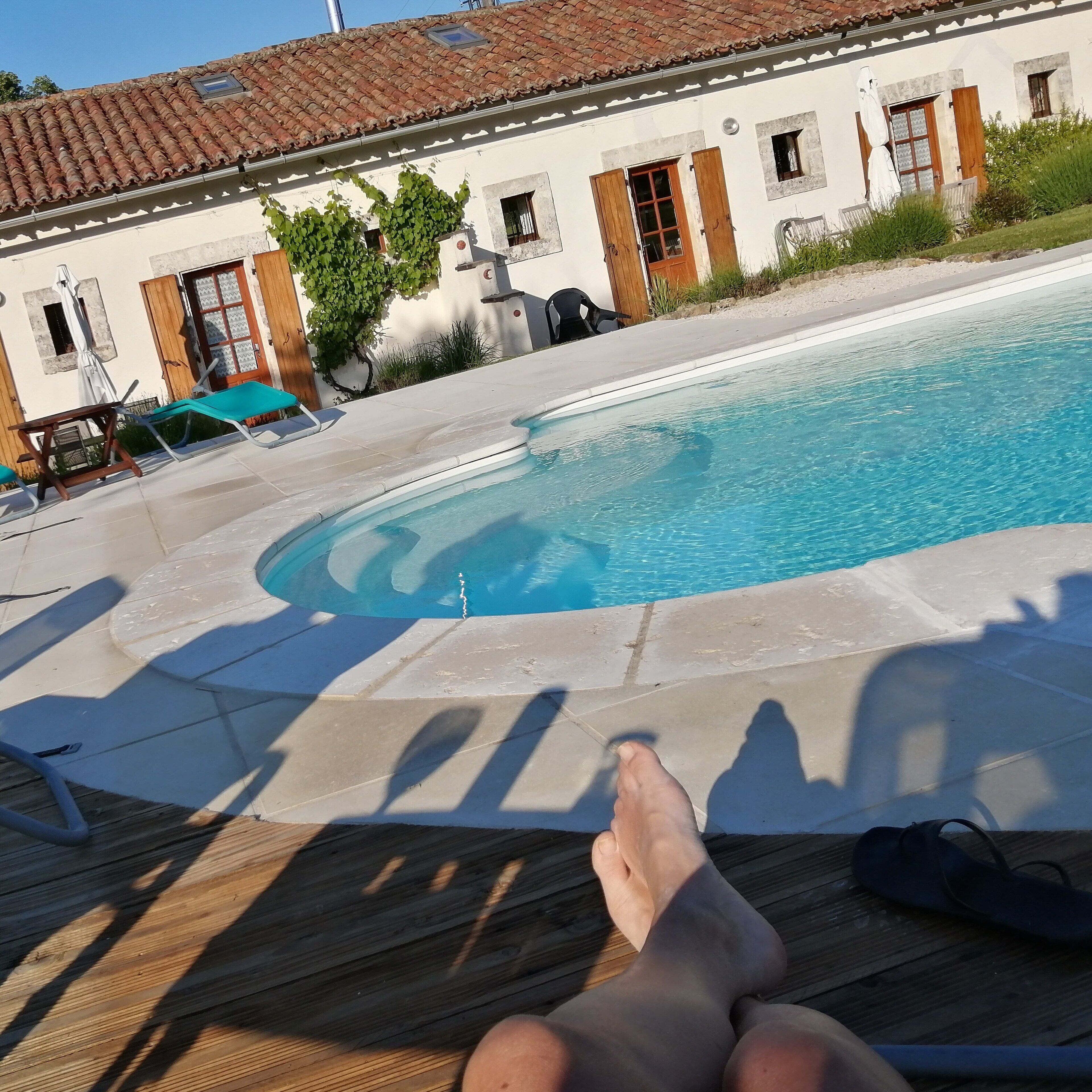 Zona de piscina con sillones de descanso y terraza de baldosas.