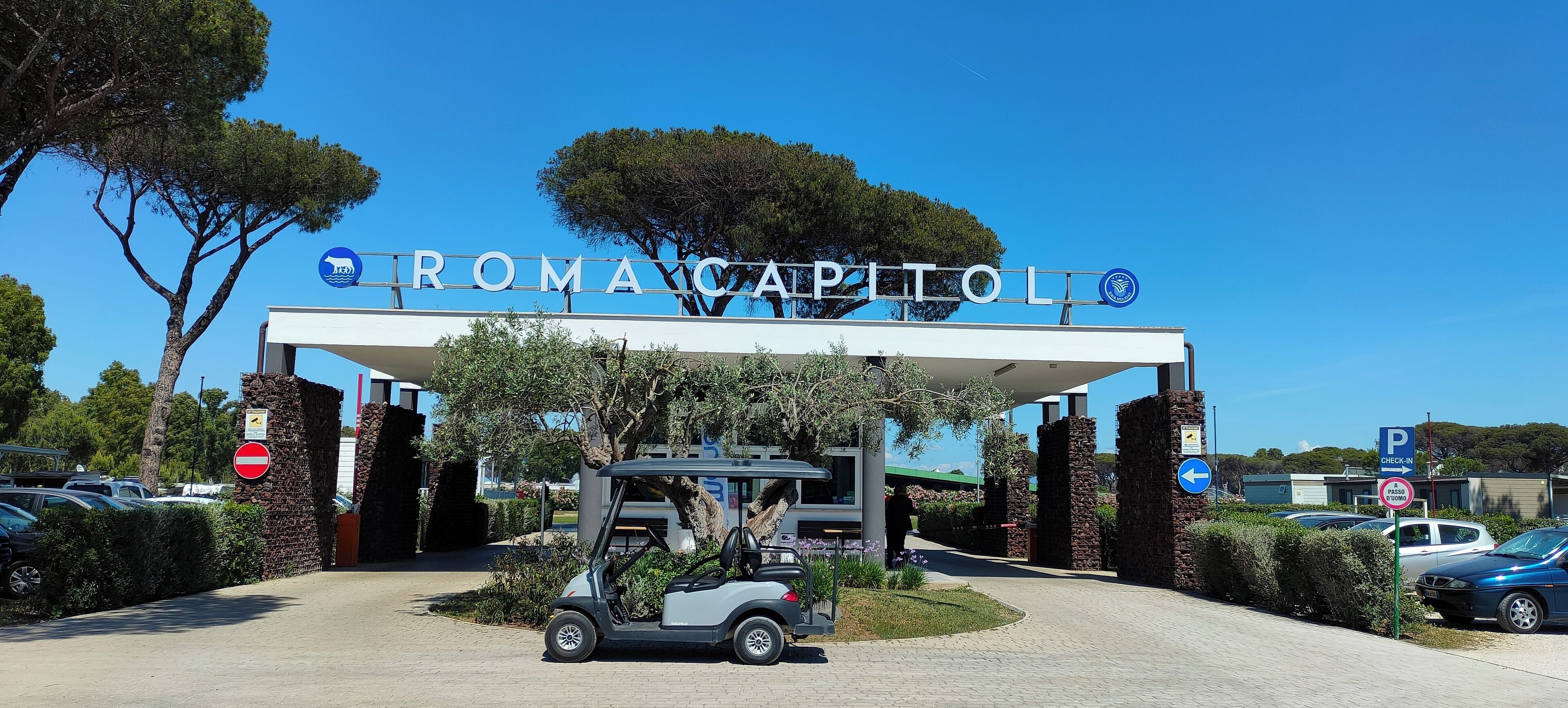 Een gebouwde ingang met een bord waarop 'ROMA CAPITOL' staat.