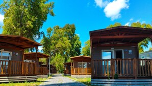 A pathway leading to wooden cabins with a clear sky above. - Camping Village Roma Capitol (Rome)