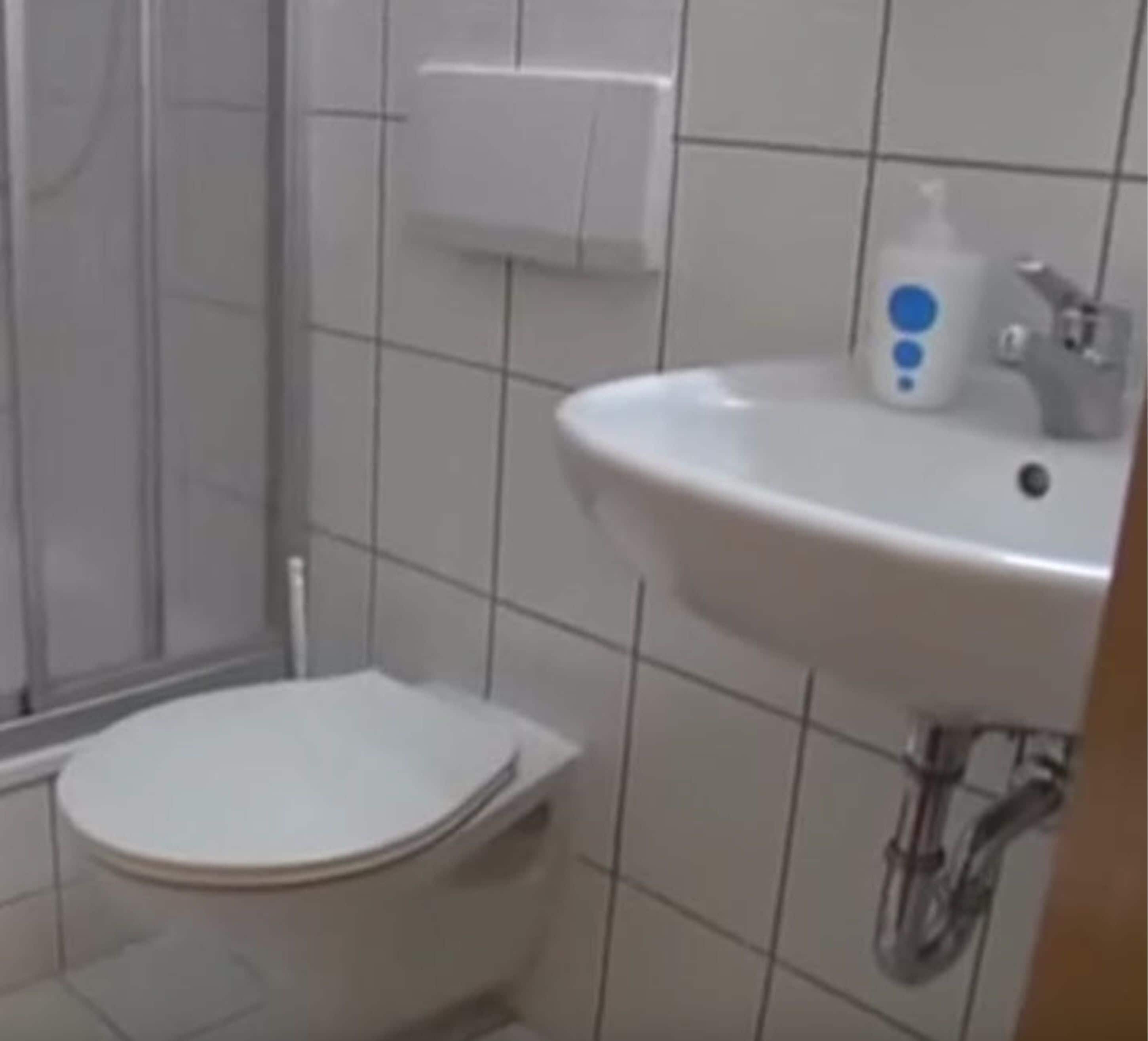 Ein kleines Badezimmer mit Toilette, Waschbecken und Dusche.