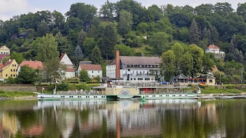 A riverside town with a row of houses and a boat docked at the pier.