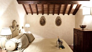 A bedroom with a bed, a nightstand, a lamp, a dresser, and a decorative bowl on the dresser. - Villa Stefano (Dicomano)