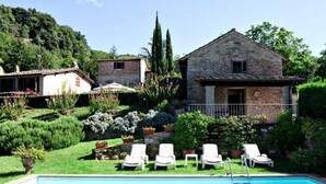 A stone house with a pool and lounge chairs. - Villa Stefano (Dicomano)