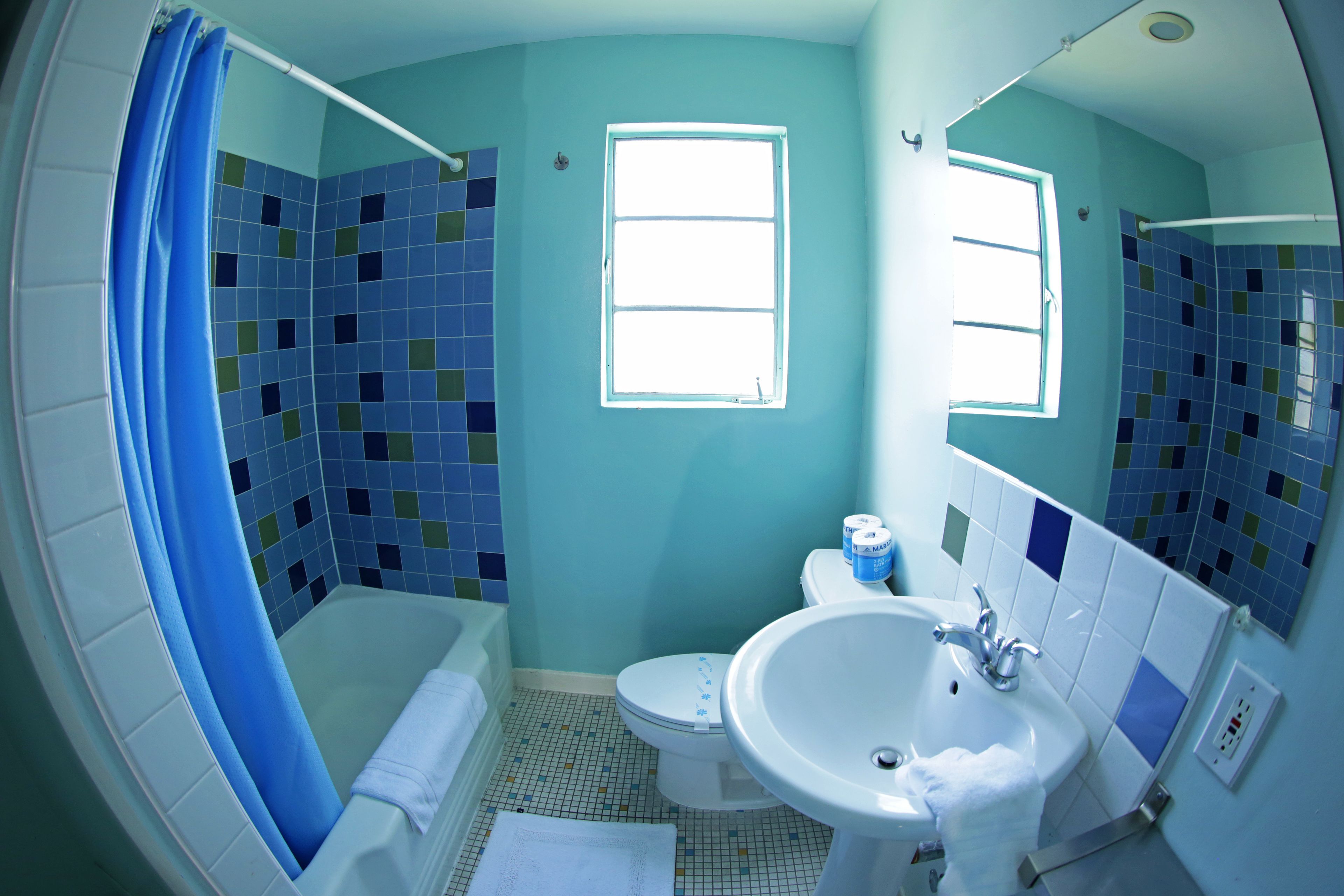 A bathroom with a bathtub, toilet, and sink.