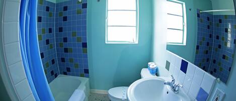 A bathroom with a bathtub, toilet, and sink.