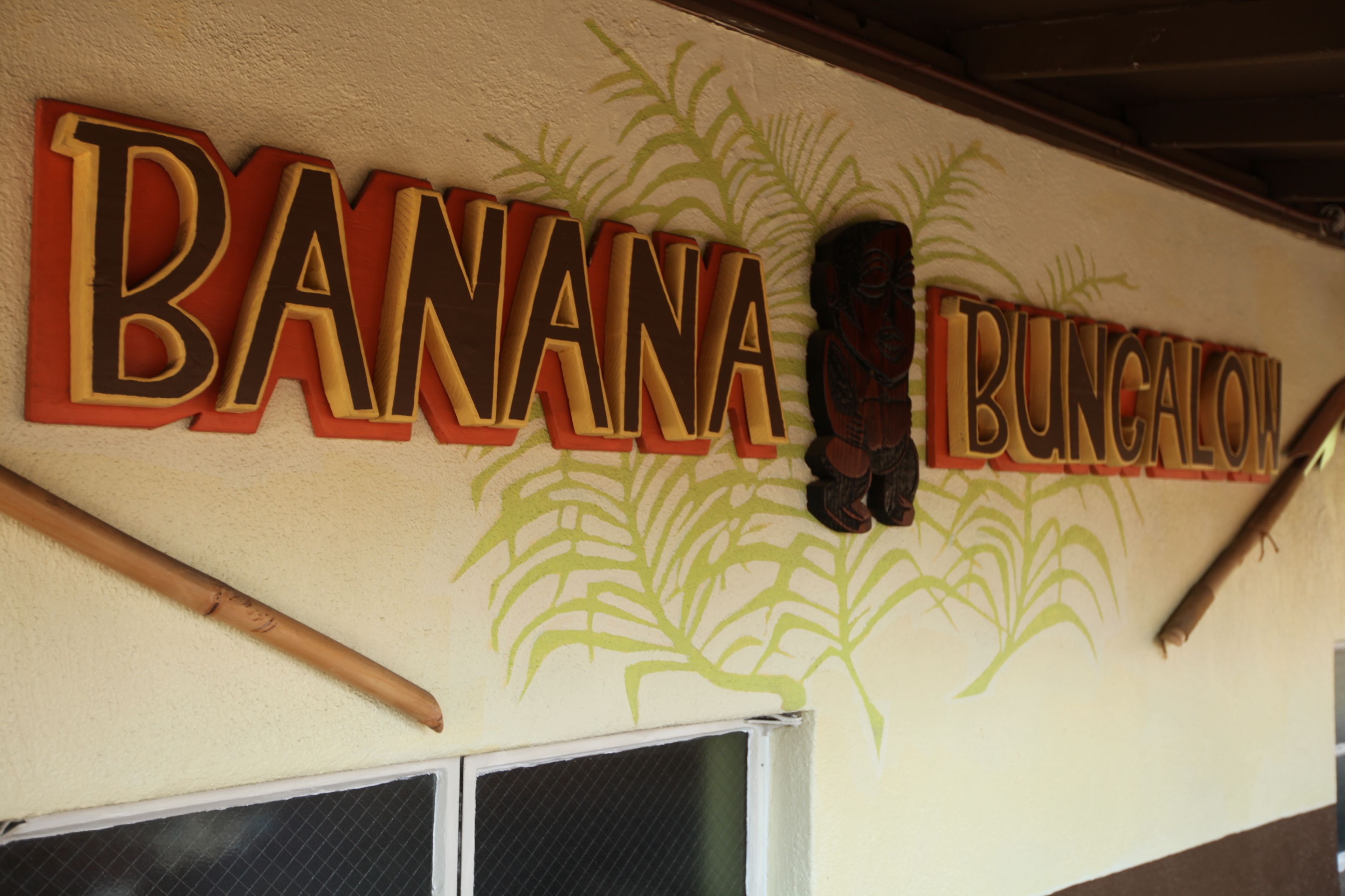 A wall with the text "BANANA BUNGALOW" and a decorative plant design.
