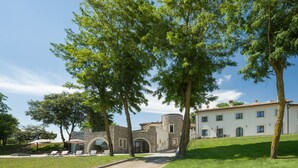 Un bâtiment doté d’une façade en pierre, d’une entrée centrale en arc de cercle et d’un toit recouvert de tuiles.