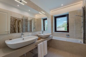 Junior suite | Badkamer | Een diep bad, een regendouche, een haardroger, badjassen