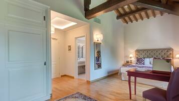 Une chambre à coucher avec un lit, des tables de chevet, un bureau et une chaise.