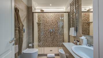 A modern bathroom with a glass-enclosed shower, a white sink, and a towel rack.