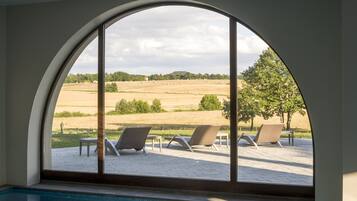 Piscina con vista despejada a un área de estar exterior y paisaje.