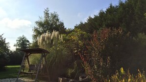 A garden with a pond, a wooden bench, and a gazebo. - Au Clos du Lit - Chambres d'hôtes (Lamballe-Armor)