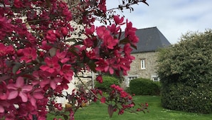 A stone building with a well-maintained garden and a hedge in front. - Au Clos du Lit - Chambres d'hôtes (Lamballe-Armor)