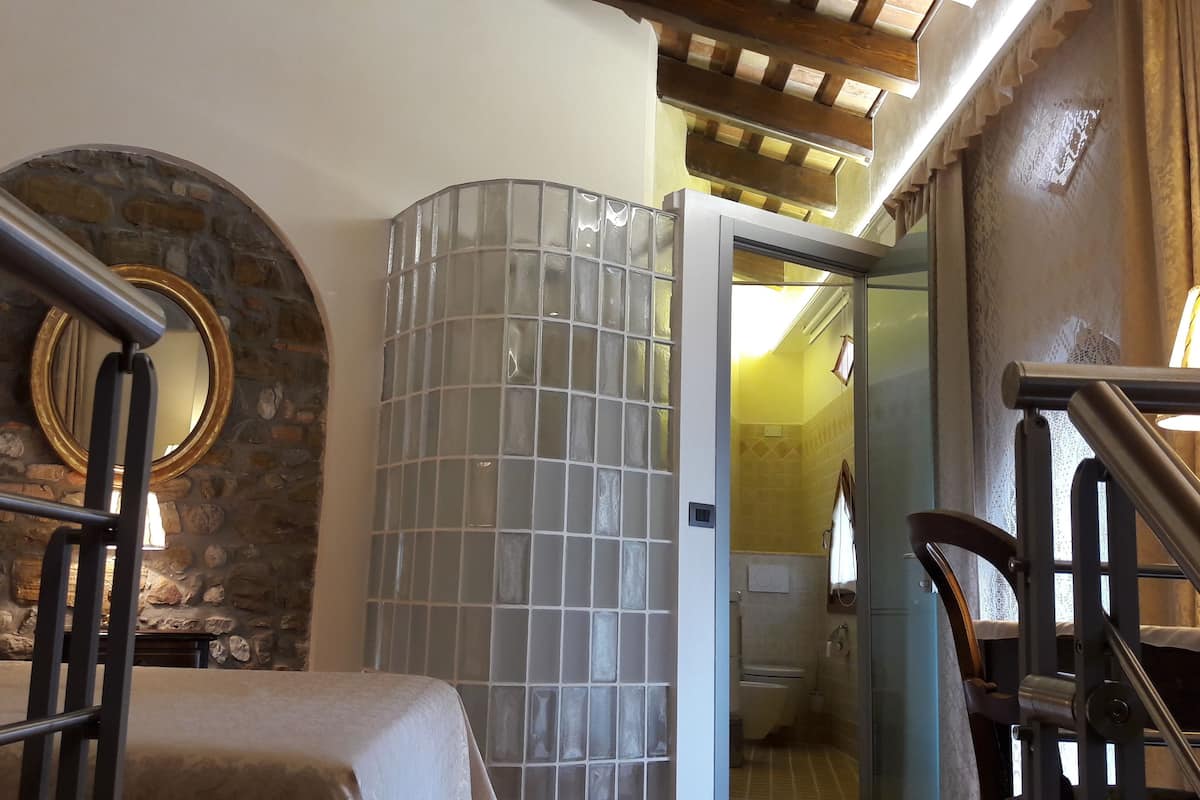 A room with a stone wall, a glass partition, and a wooden ceiling.