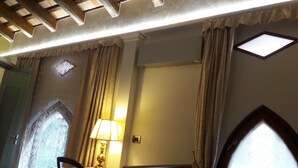 Une pièce avec un plafond en bois, une fenêtre donnant sur un beau paysage, une porte et une lampe.