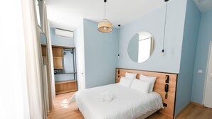Une chambre à coucher avec un lit en bois, un miroir rond et une armoire.