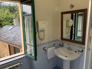 Un baño con un lavamanos blanco, un espejo y un teléfono.