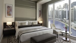 Una habitación de hotel moderna con una cama grande, un área de descanso y vistas de la ciudad.