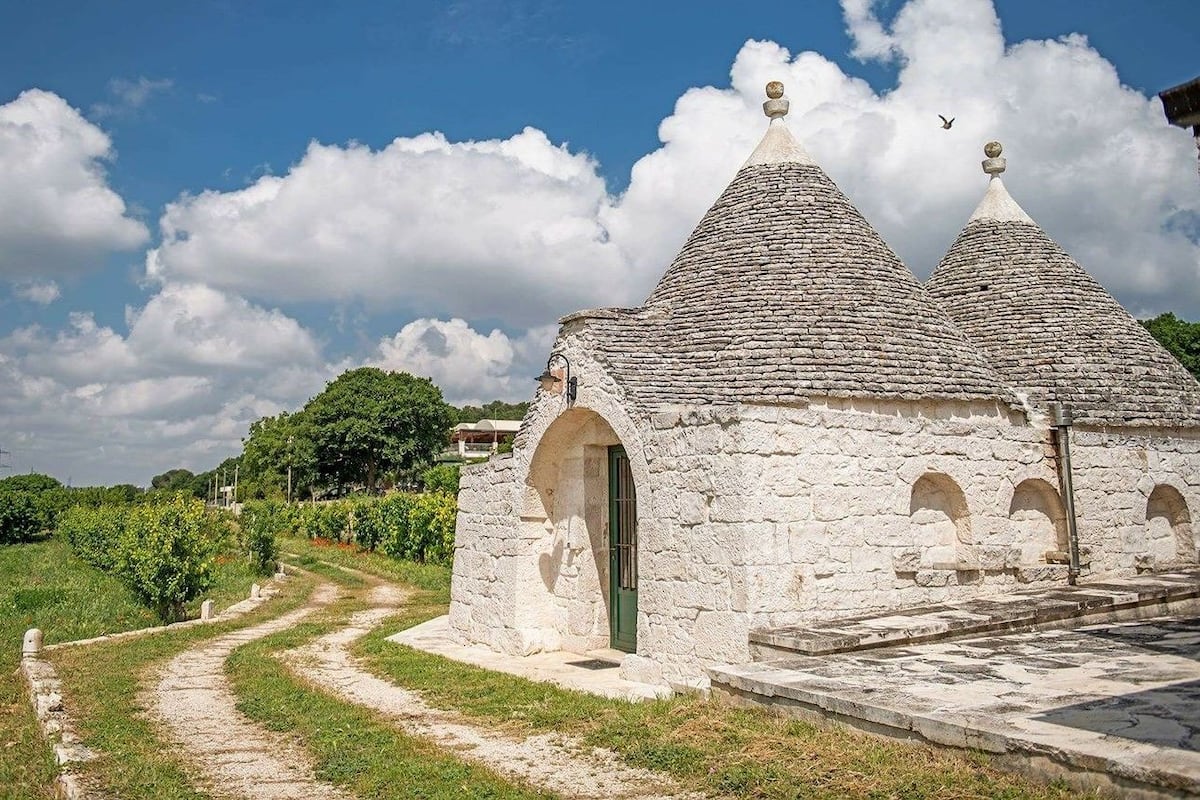 Ein Steinhaus mit einer grünen Tür und einem steinernen Weg, der dorthin führt.