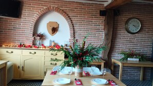 Un coin repas avec un mur en briques, une horloge et une décoration de Noël en guise de centre de table.