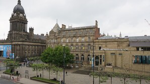 A historic building with a prominent clock tower, a large central dome, and a series of arched windows. - Victoria House Apartments (Leeds)