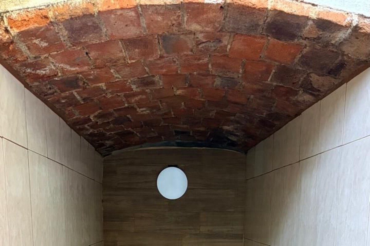 A spa room with a brick ceiling, tiled walls, and a rectangular pool.