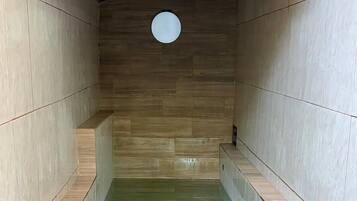 Un cuarto de spa con techo de ladrillo, paredes de azulejos y una piscina rectangular.