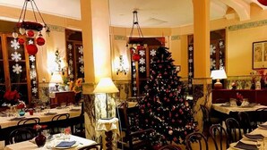 A restaurant with tables set for dining, a Christmas tree, and holiday decorations. - Bed & Breakfast Ristorante Belvedere (Subiaco)