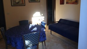 A dining area with a round table and chairs, a sofa, and three framed pictures on the wall. - Bed & Breakfast Ristorante Belvedere (Subiaco)
