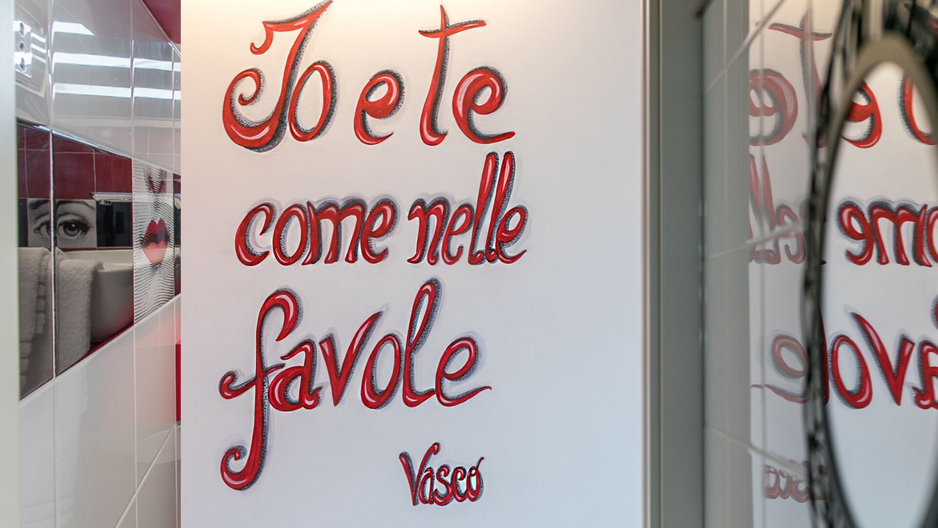 Un mur doté d’une surface réfléchissante et offrant une vue partielle sur une salle de bain.