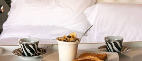 A breakfast setup with a bowl of cereal, two cups, and toast on a tray.