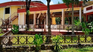 A building with a covered outdoor seating area, stone walls, and a brick oven. - Villas Kin Ha (Palenque)