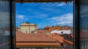 A view from a window overlooking a cityscape with red-tiled roofs and various buildings. - Caruso Suite (Sorrento)