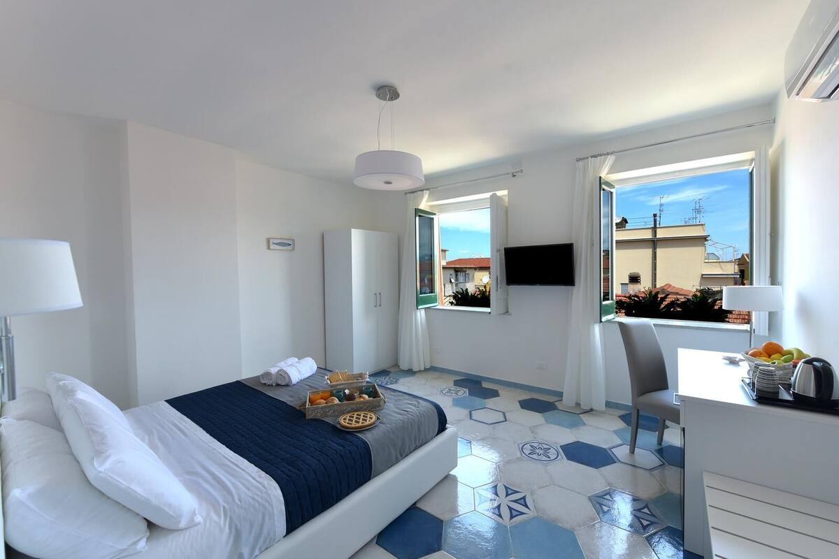 Deluxe Triple Room | Minibar, in-room safe, desk, blackout drapes