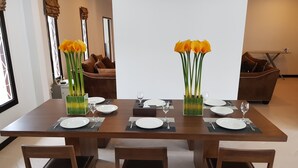 Een eettafel voor vier personen, met stoelen, een bank en een salontafel op de achtergrond.