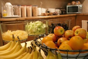 A kitchen counter with various fruits and a coffee maker. - R & R Inn & Suites (Camrose)
