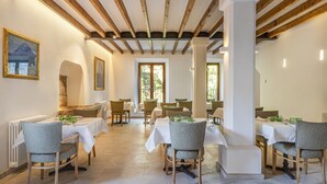 A dining area with multiple tables, chairs, and a rustic ceiling with exposed beams. - Son Grua Agroturismo - Adults Only (Pollenca)