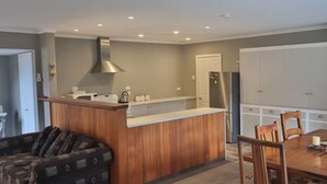 A compact kitchen with a wooden island, a dining table with chairs, and a built-in oven.
