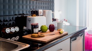 A kitchen with a modern design, featuring a wooden countertop, a toaster, a jar of jam, and two apples. - Lourdas amazing view - Studio Marinos. (Vlachata)