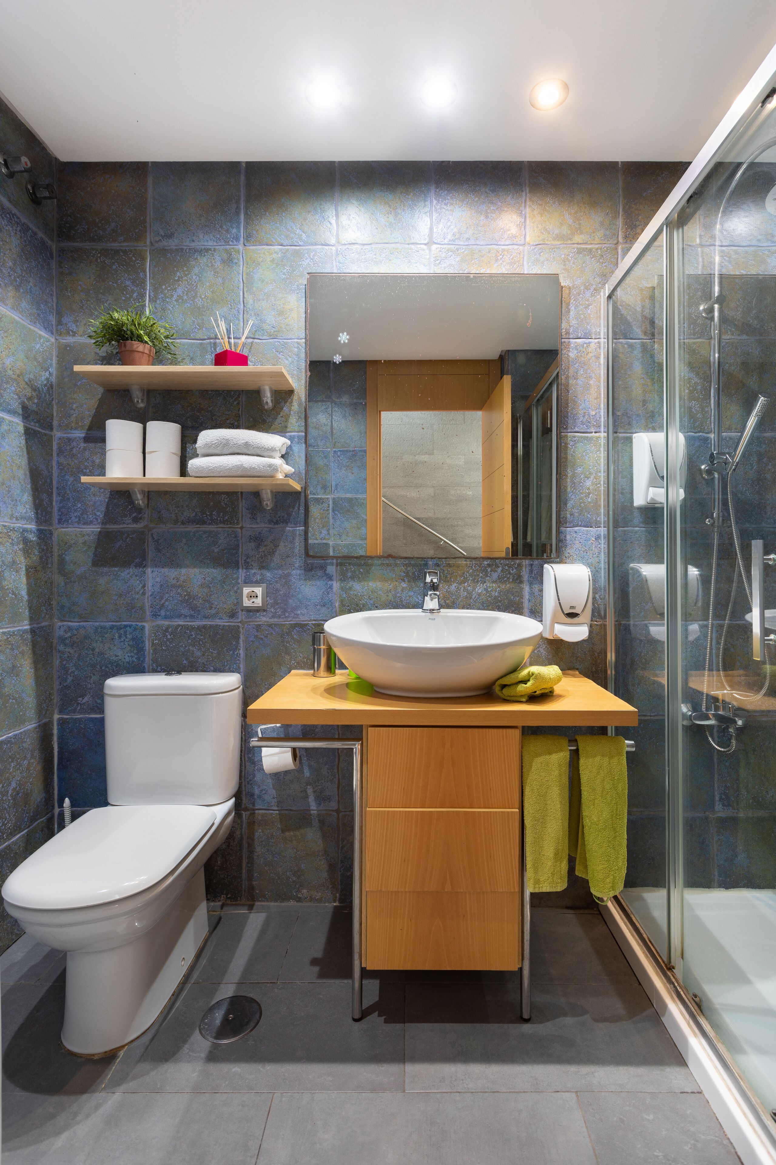 Een moderne badkamer met toilet, wastafel en douche.