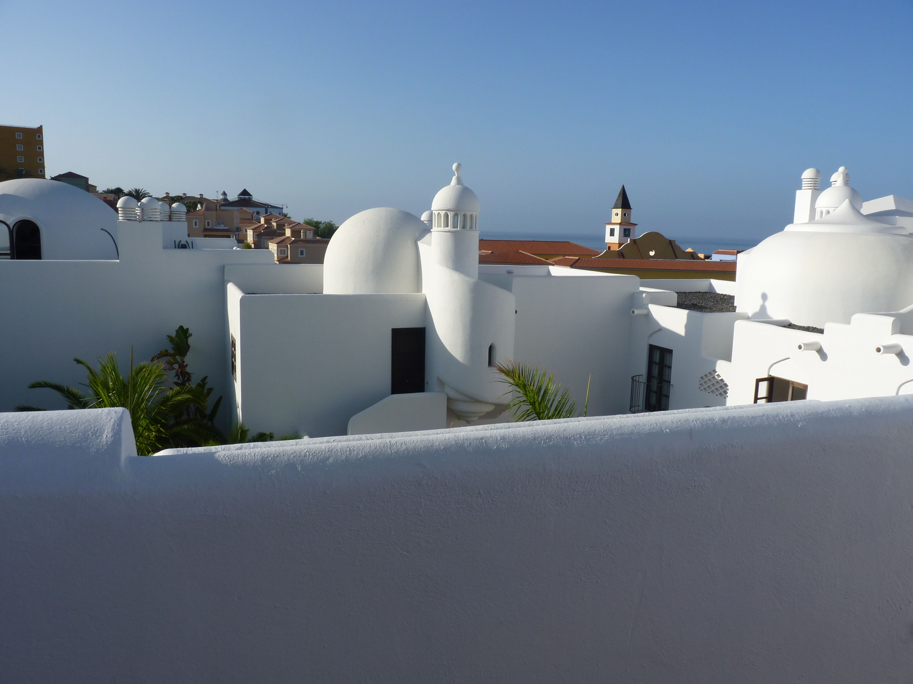 Un pueblo costero con edificios de paredes blancas y techos abovedados, probablemente una zona histórica o cultural.