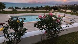Une piscine avec vue sur la mer et les montagnes en arrière-plan.