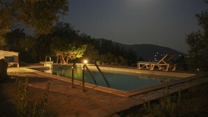 A swimming pool with a moon in the background, surrounded by trees and a mountain. - Country Villa Kalimera | Private Hilltop Villa in Skopelos with Pool & Views (skopelos)